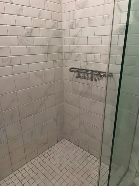 After: the same Grout Grouch shower project with renewed grout and floor