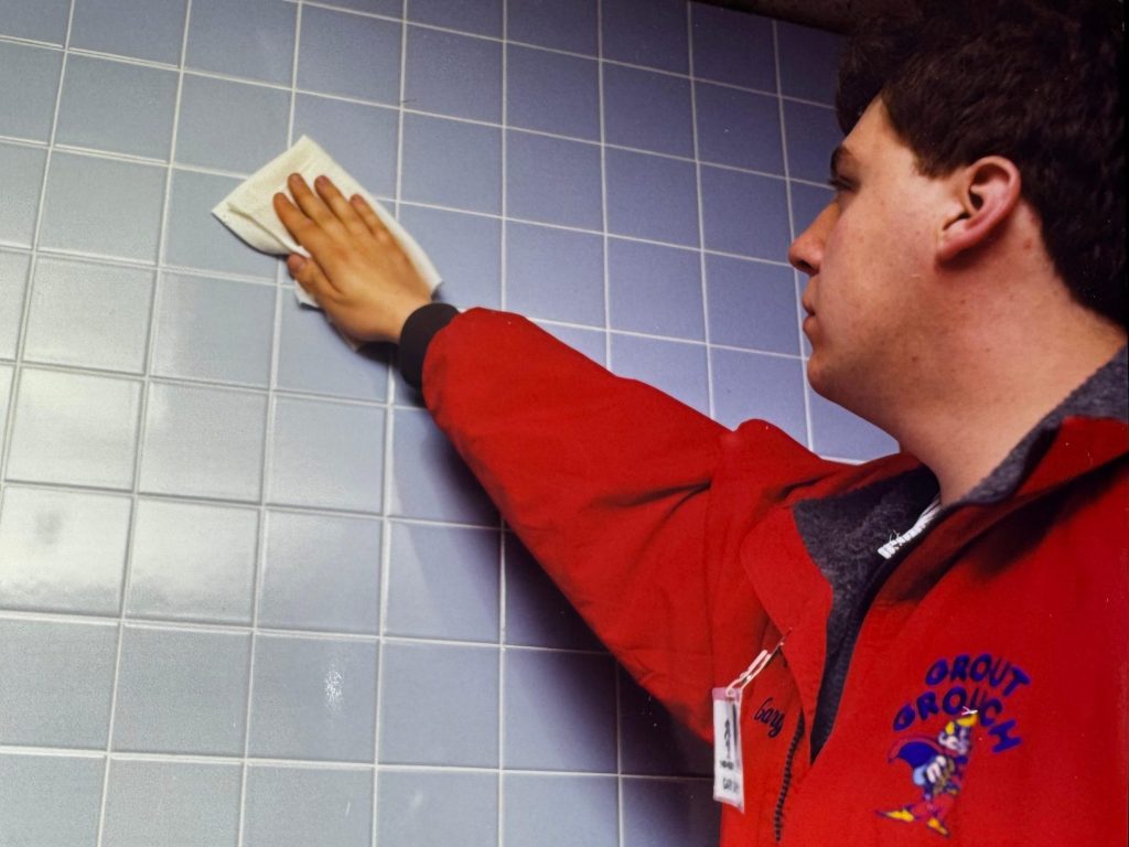 Gary Derych, founder of Grout Grouch, working on a tiled wall