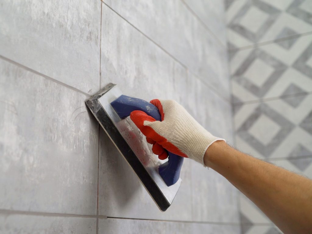 Applying grout to a tiled wall
